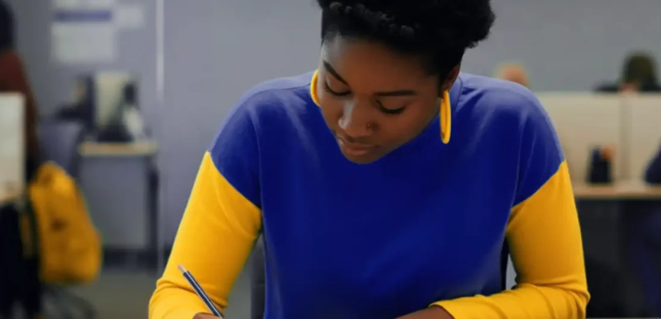 black woman writing with pen